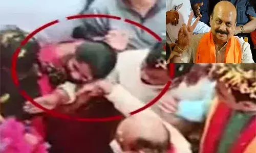 కర్నాటక సీఎంపై మహిళ ముద్దుల వర్షం.. కుడిచేతిని పట్టుకుని..!
