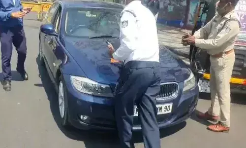 బీఎండబ్ల్యూ కారేసుకుని.. ఏకంగా పోలీసు మీదకే..