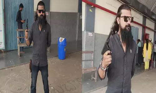 థియేటర్ వ‌ద్ద గ‌న్‌తో యువ‌కుడి హ‌ల్‌చ‌ల్‌